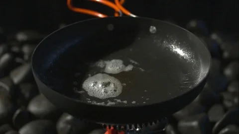 Slow motion fish dropping into frying pan Stock Footage 77688907