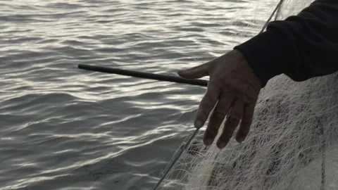 Slow Motion of Fisherman's Hands Pulling a Traditional Fishing Net at Dawn Stock Footage 320635159