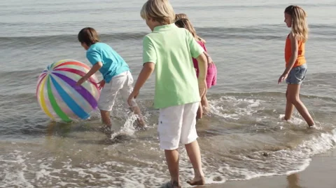 Slow motion of five children playing in surf with beach ball. Stock Footage 43672865