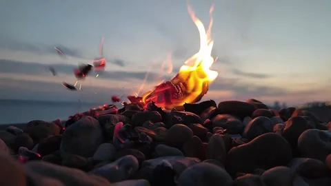 Slow motion flames and exploding flint stones on a pebble beach Stock Footage 306104513
