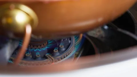 Slow-Motion Flames Beneath Copper Hot Pot on Gas Burner Stock Footage 312583532