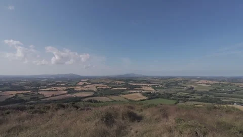 Slow motion flat color hilltop field overview under clear sky Stock Footage 340449465