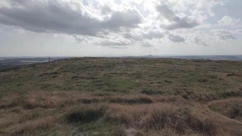 Slow motion flat profile rocky terrain on grassy hill slope Stock Footage 340449171