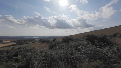 Slow motion flat profile view of clouds over hillside landscape Stock Footage 340446331