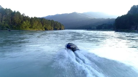 Slow motion flight above motor boat on the mountain river Stock Footage 78568709