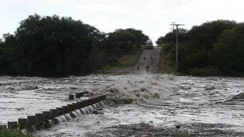 Slow motion of flood, strong violent river passing over bridge 스톡 동영상 118995049