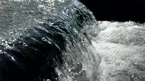 Slow-motion flowing water at a weir in the sparkling sun with bubbles Видео 343911893