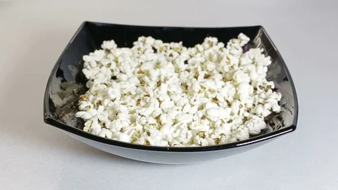Slow motion Fluffy bright pieces of popcorn falling against a white background Stock Footage 69851420