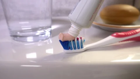 Slow motion: Fluoride toothpaste being squeezed onto a toothbrush. Stock Footage 95784160