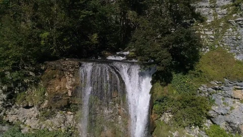 Slow motion flying above the waterfall in the green forest in georgia Stock Footage 100002011