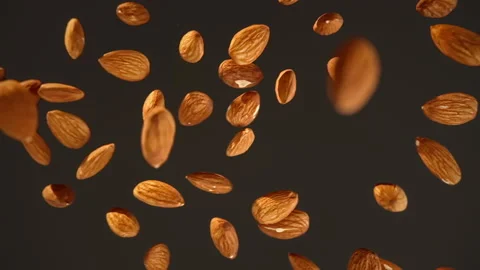 Slow motion of flying almonds a black background Stock Footage 148163072