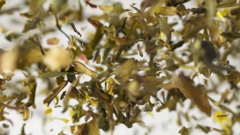 Slow motion of flying aromatic black dry tea on the white background Video stock 148553012