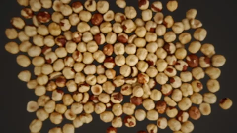 Slow motion of flying peeled hazelnuts a black background Vídeo Stock 148162303
