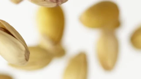 Slow motion of flying pistachios on the white background close up Video stock 148554111