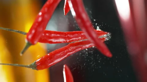 Slow Motion  of Flying Red Chilli Peppers in the Air falling down to water 4k Stock Footage 131742109