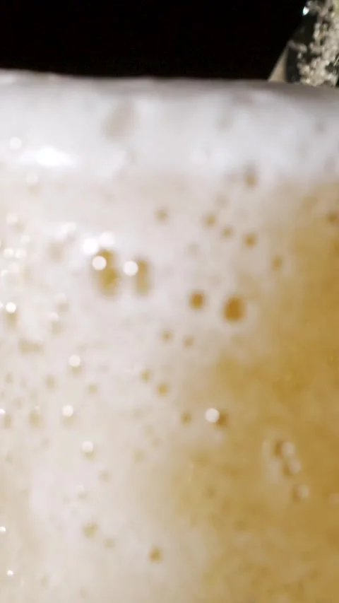 Slow motion foam and bubbles rising in a glass of beer Stock Footage 340482656