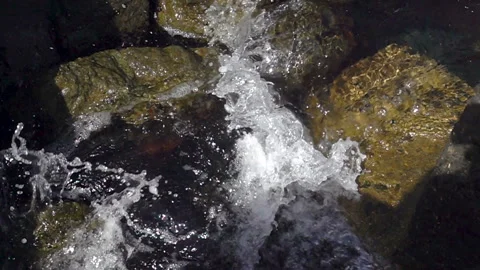 Slow motion foam wave washes the stones in the water Stock Footage 112353836