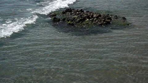 Slow motion foam wave washes the stones in the water on the coast Stock Footage 112354141