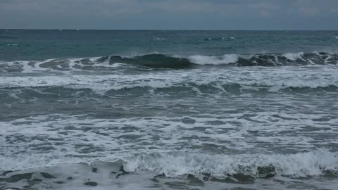 Slow motion of foamy waves falling towards sand beach under low the sunlight Stock Footage 234033698