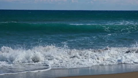 Slow motion of foamy waves falling towards sand beach under low the sunlight Stock Footage 234033703