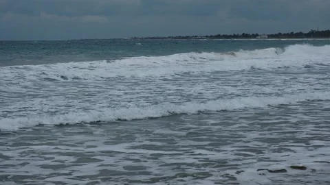 Slow motion of foamy waves falling towards sand beach under low the sunlight Stock Footage 234033743