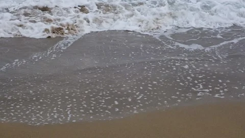 Slow motion of foamy waves falling towards sand beach under low the sunlight Stock Footage 234033772