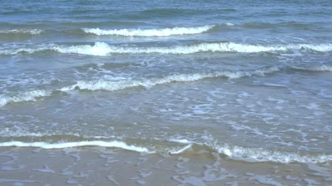 Slow motion of foamy waves rolling towards the sand beach Video stock 221397614
