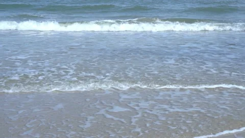 Slow motion of foamy waves rolling towards the sand beach Video stock 221397624