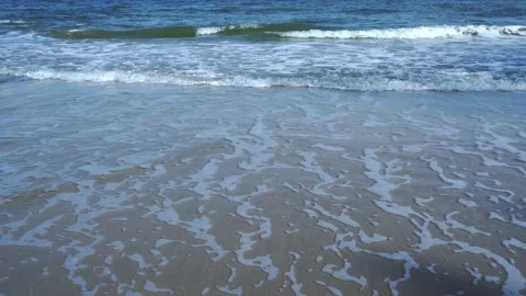 Slow motion of foamy waves rolling towards the sand beach Video stock 221400871