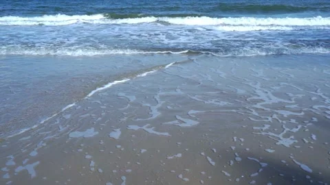 Slow motion of foamy waves rolling towards the sand beach Video stock 221400872