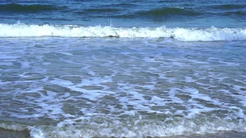 Slow motion of foamy waves rolling towards the sand beach Video stock 221980068