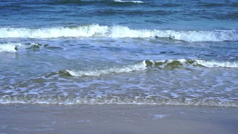 Slow motion of foamy waves rolling towards the sand beach Video stock 221980189