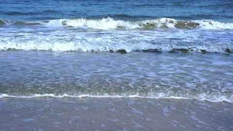 Slow motion of foamy waves rolling towards the sand beach Video stock 221980230