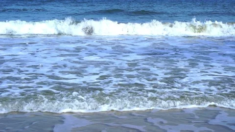Slow motion of foamy waves rolling towards the sand beach Video stock 221980242