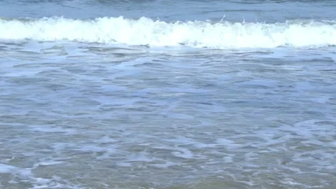Slow motion of foamy waves rolling towards the sand beach, golden beach meeti 動画素材 222045185