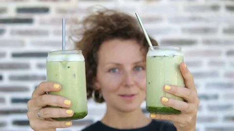 Slow motion with focus on glasses with milkshakes. They are held in the hands of Stock Footage 220106493