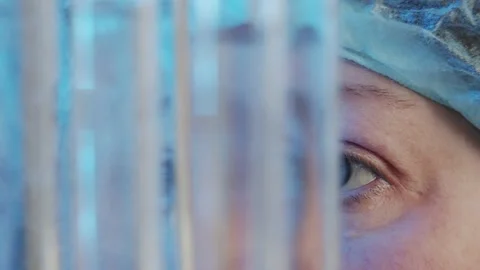 Slow motion focused eyes watching the diffusion of liquids in test tubes in the Stock Footage 233030802