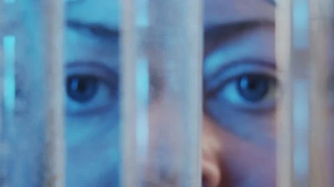 Slow motion focused eyes watching the diffusion of liquids in test tubes in the Stock Footage 233030940