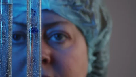 Slow motion focused eyes watching the diffusion of liquids in test tubes in the Video stock 233030981
