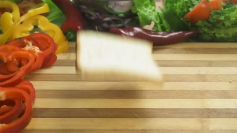 SLOW MOTION FOOD: a piece of bread falls on the finished burger and chips fly Stock Footage 87835249