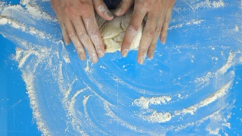 Slow motion footage. Baker hand kneading dough with rolling pin. Top view Stockbeeldmateriaal 88452269