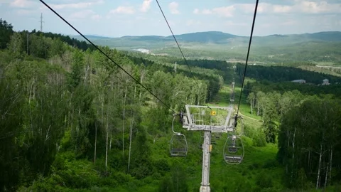 Slow-motion footage of a cable car descent in a wooded area. Stock Footage 274064134
