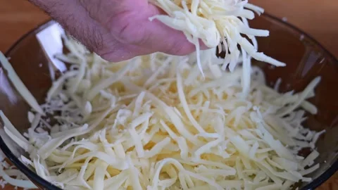 Slow-motion footage of cheese grating in macro detail. A man's hand works t.. Video stock 280036049