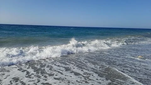 Slow motion footage of foaming waves crashing noisily on a sandy beach on the Stock Footage 289472023