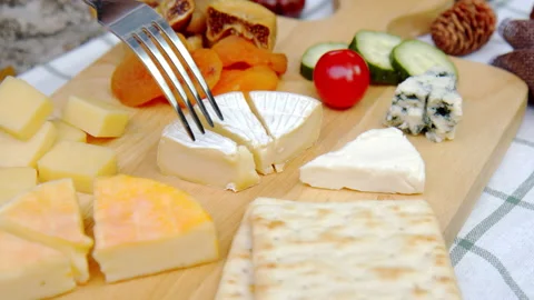 Slow Motion - Footage of a fork picking a slice of Brie cheese in a platter. Stock Footage 148080512