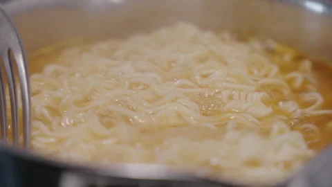 Slow motion footage of a fork stirrig in a hot pot of noodles 스톡 동영상 332684646