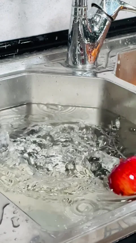Slow Motion Footage of Fresh Red Apple Falling into Modern Kitchen Sink Stock Footage 337740821