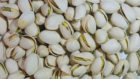 Slow motion footage of a group of raw pistachios cracking open. Stock Footage 245943242