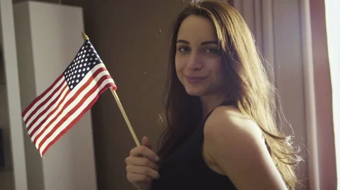 Slow motion footage how young caucasian female is standing in a room and waving Stock Footage 61337206