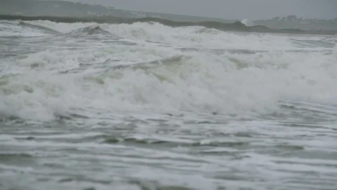 Slow motion footage of large storm waves crashing onto a sandy beach Video stock 72484764